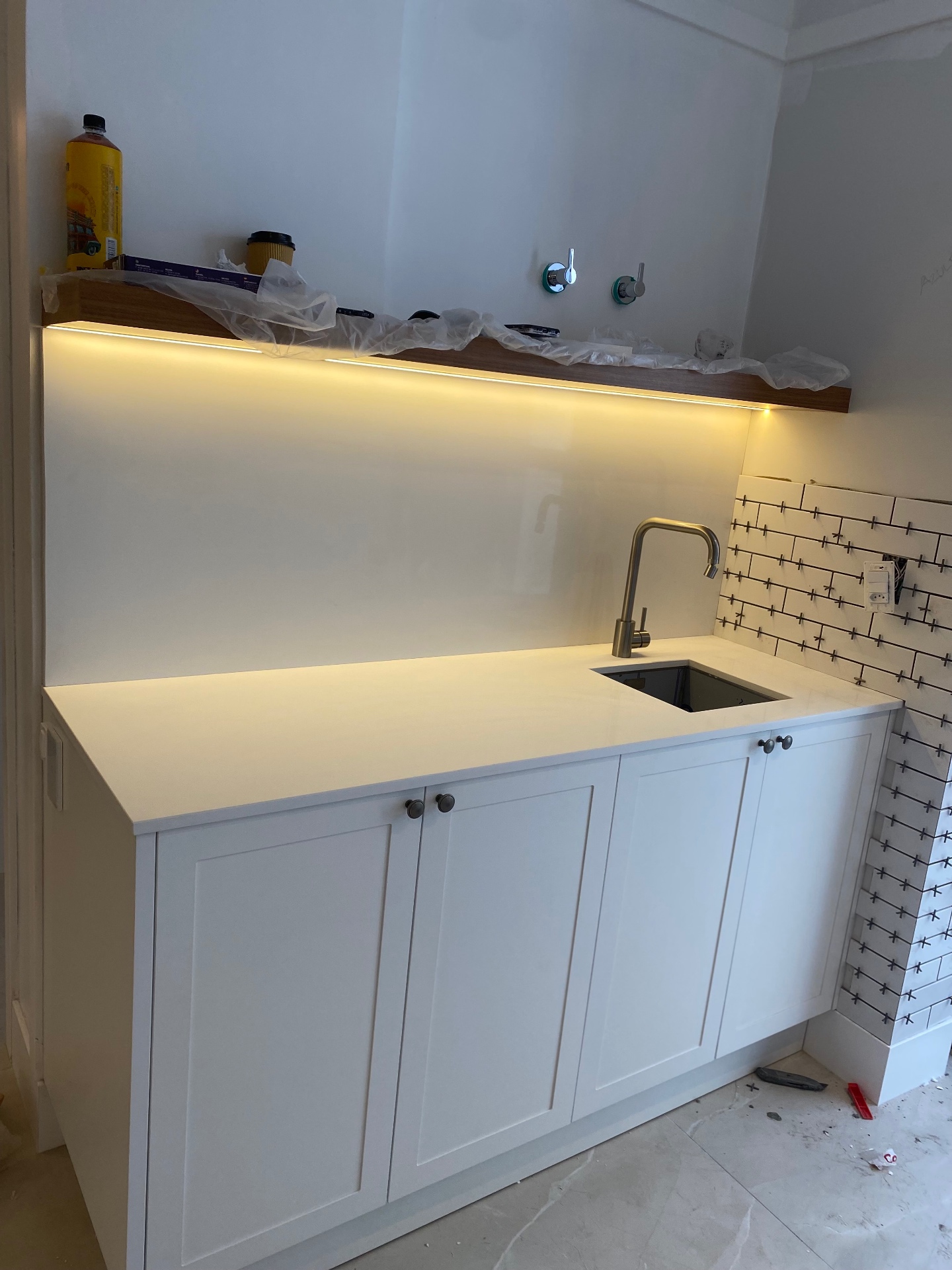 Área gourmet com bancada em quartzo branco e iluminação LED
